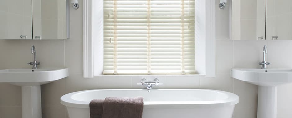 Cream faux wood blinds in white bathroom