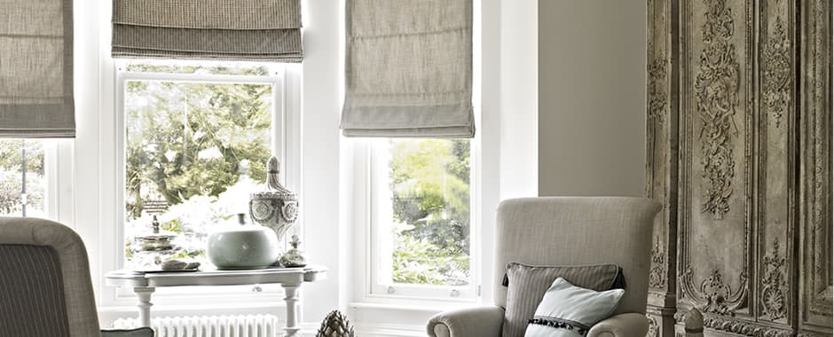 Brown roman blinds in lounge bay window