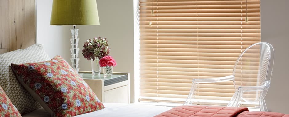 Closed light wood venetian blind in bedroom