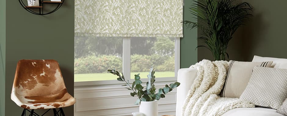 Green laurel patterned roller blinds in green living room