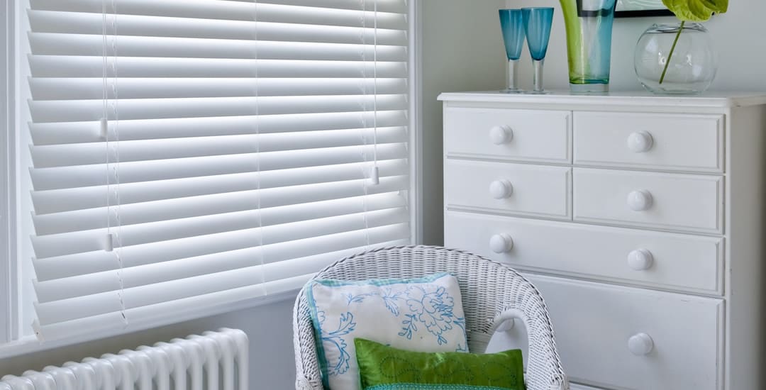 Closed white wooden blinds in sitting room