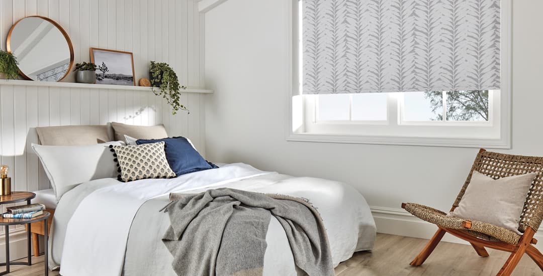 Grey leaf patterned blackout roller blinds in bedroom