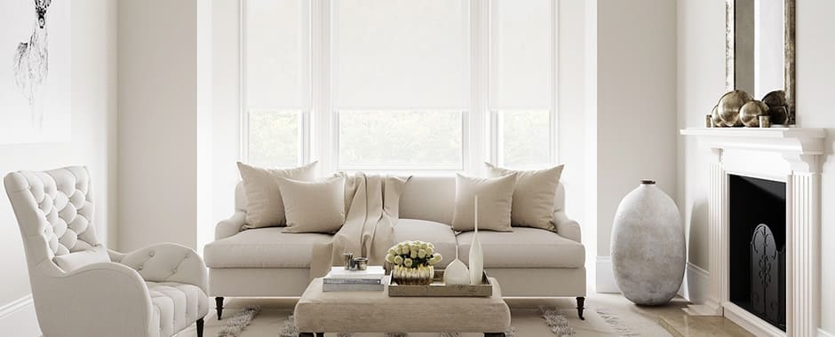 Pure white roller blinds in living room bay window