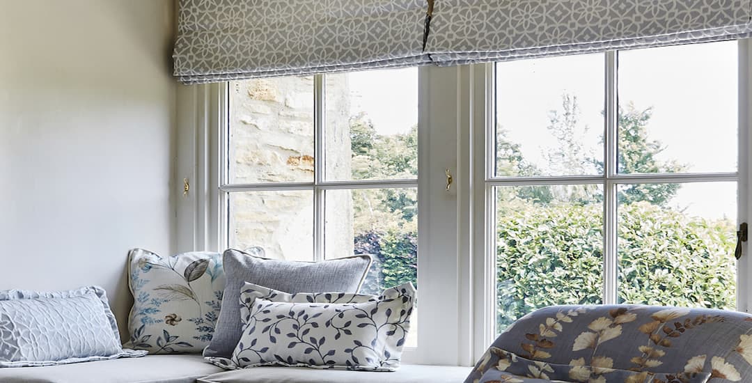 Silver and grey patterned roller blinds in window