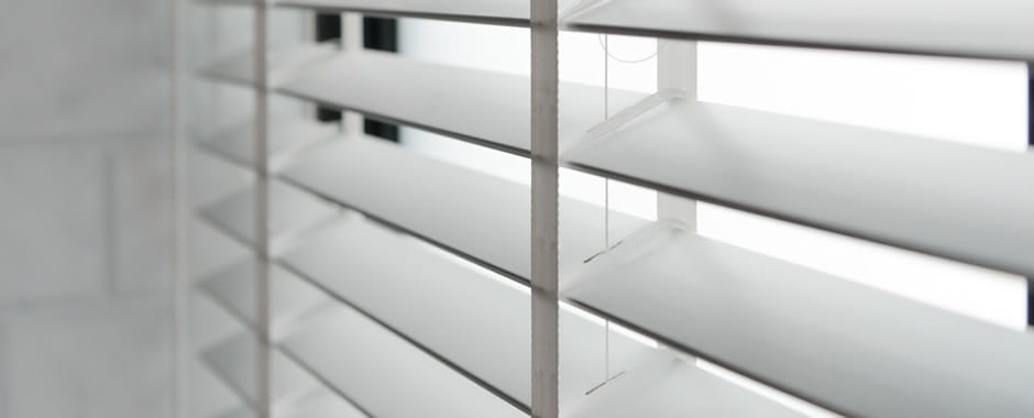 White faux wood blinds with tapes closeup