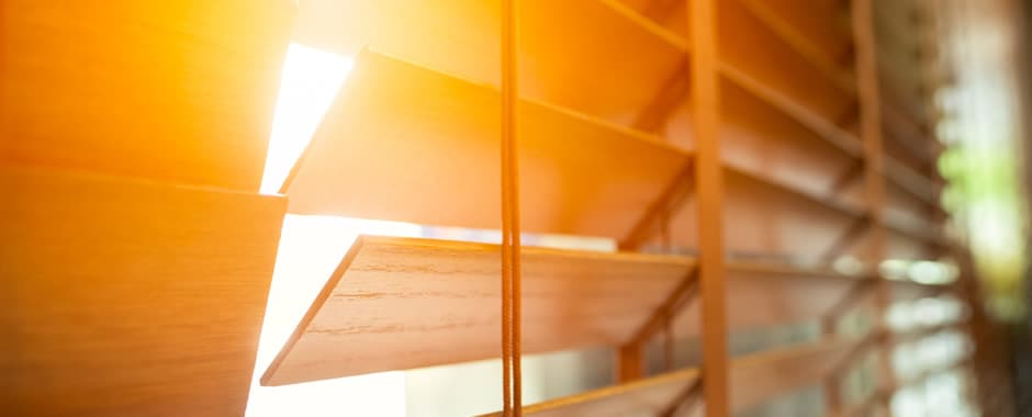 Closeup of wooden blinds in early morning sunlight