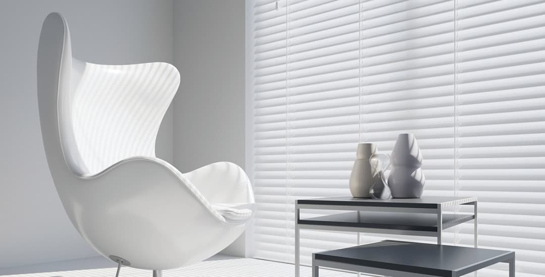 Large white wooden blinds in modern sitting room