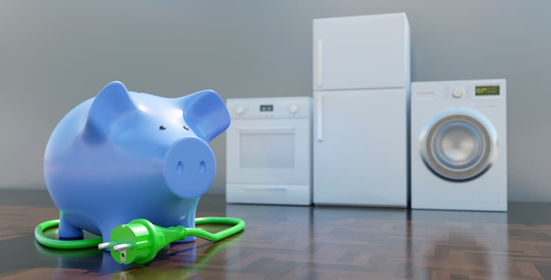 Piggy bank and power cord in front of unplugged home electric appliances