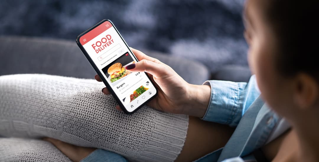 Woman using a mobile phone to order food from the delivery app