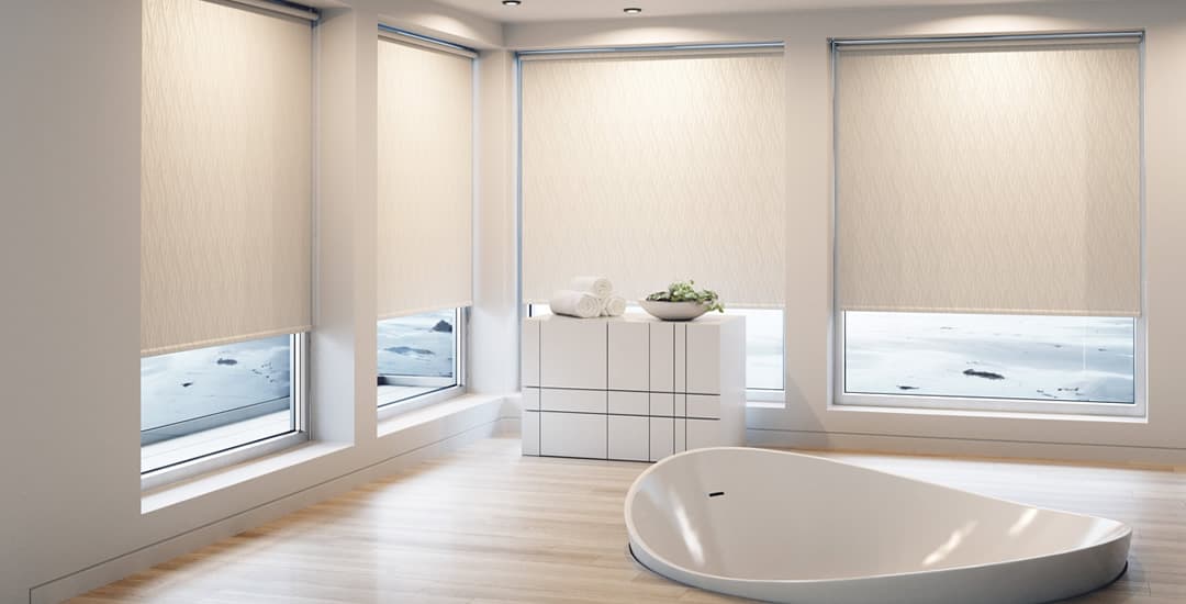 Beige patterned waterproof roller blinds in a large bathroom with sunken bath