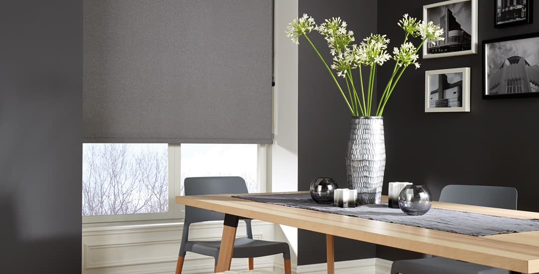 Textured dark grey roller blinds in a dining room