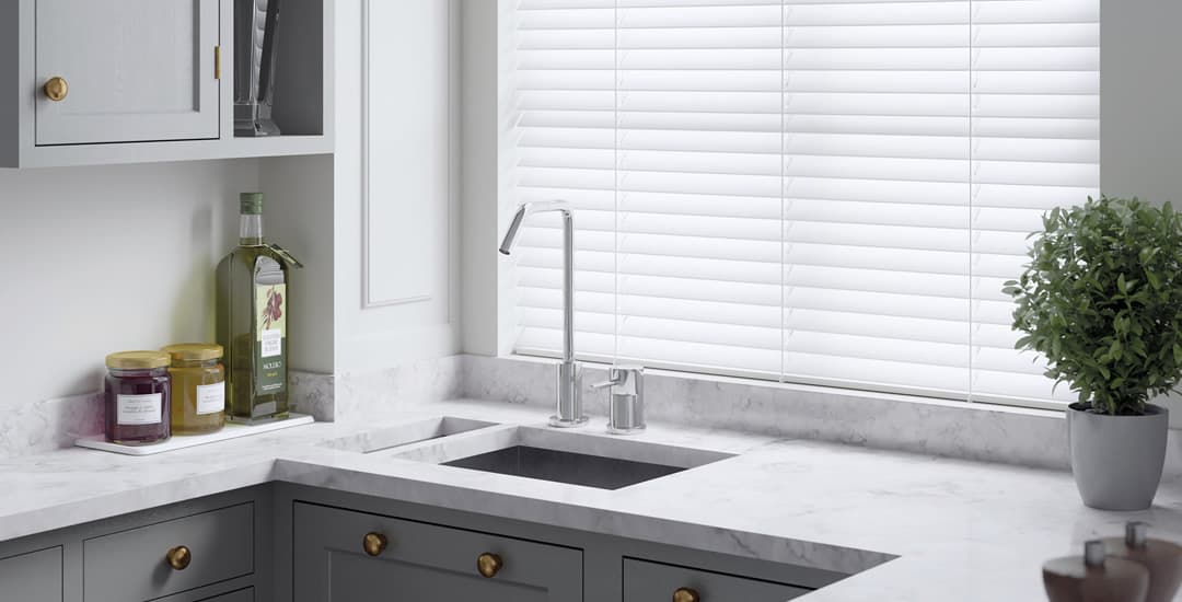 White waterproof PVC faux wood blinds above a kitchen sink