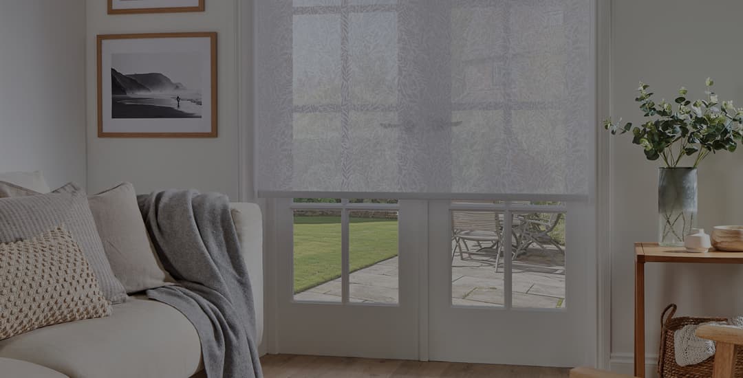 Sheer roller blinds in living room at dusk